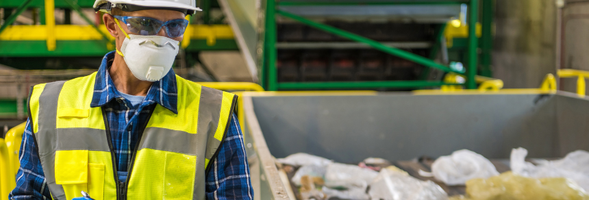 Image of worker wearing face mask, high vis jacket and goggles in an industrial environment